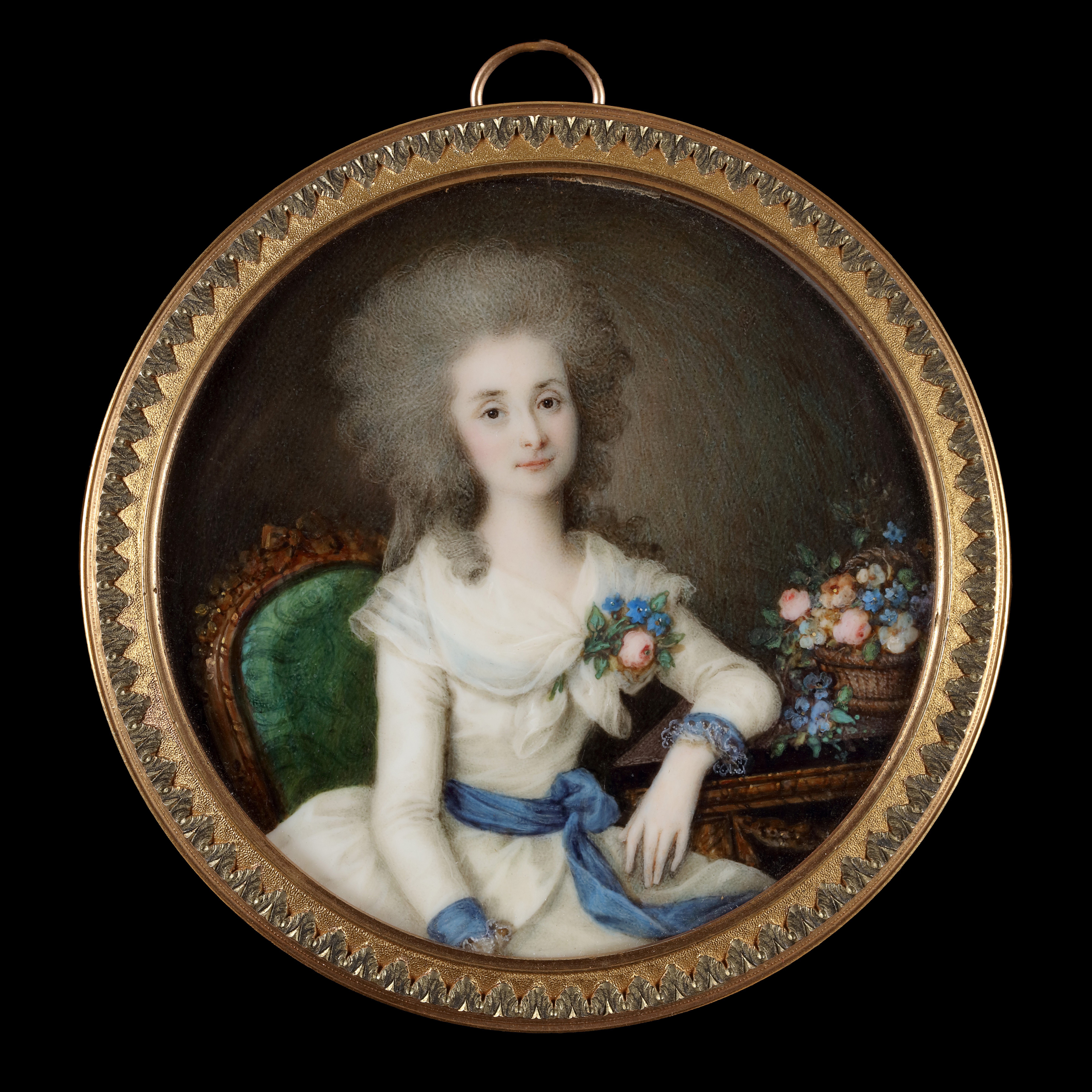 Portrait miniature of a Lady, wearing white dress with blue ribbon around her waist and cuffs, fichu scarf tied around her shoulders and a posy pinned to her corsage, hair worn curled and powdered, resting her left arm on a table with a basket of flowers